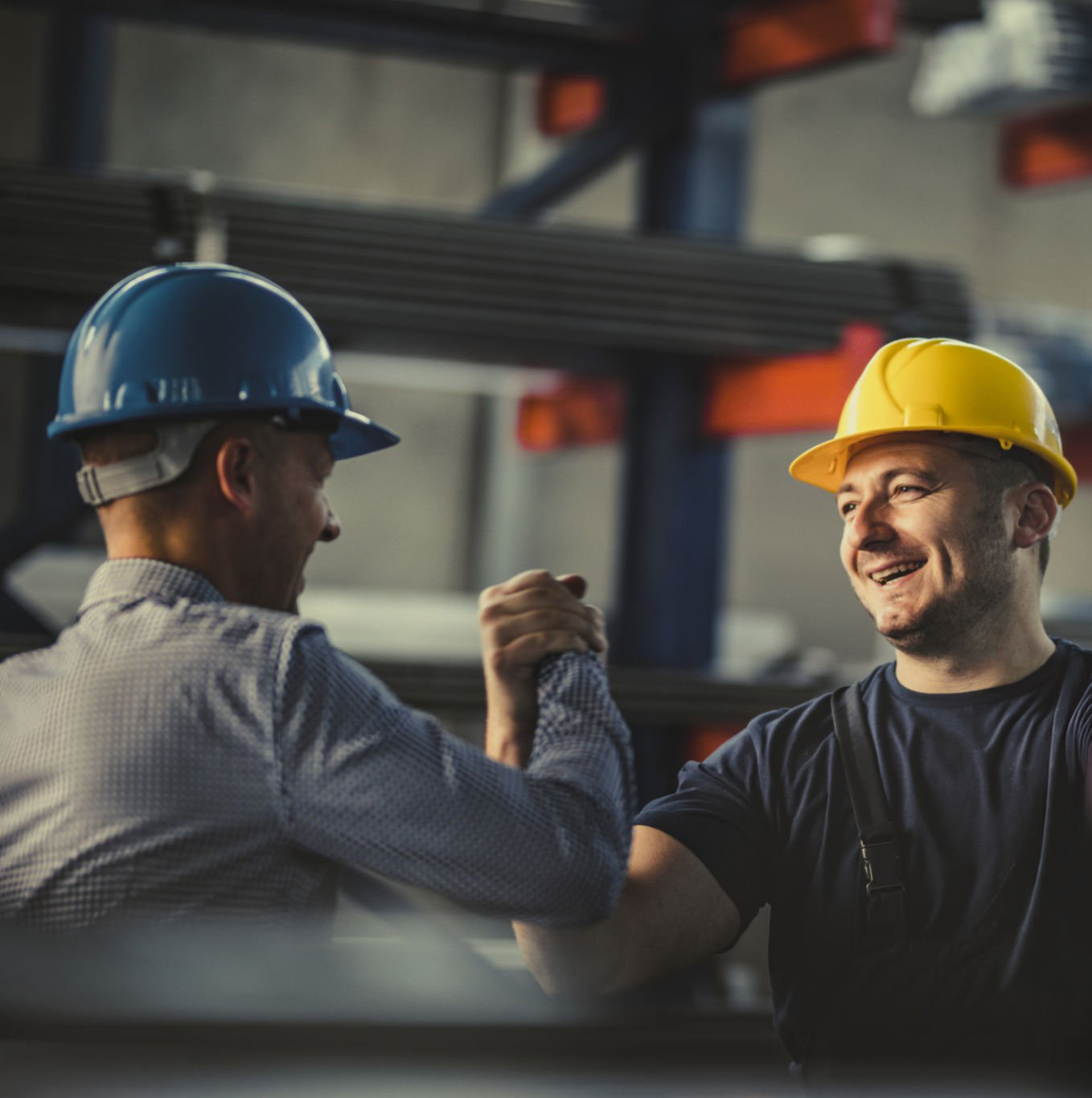 Un ouvrier métallurgiste heureux salue son directeur dans une usine d'aluminium.